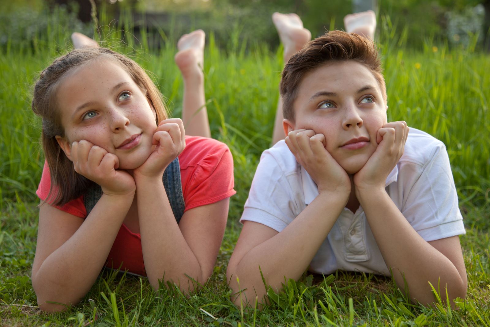 two kids laying on grass