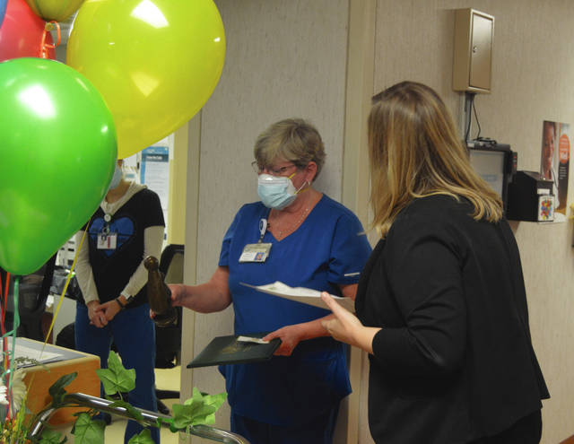 Wayne HealthCare RN and Charge Nurse Deb Osborne looks over The Healing Touch Sculpture she was presented by VP of Patient Care Services and Chief Nursing Officer Kim Freeman as part of the DAISY Award Wednesday.