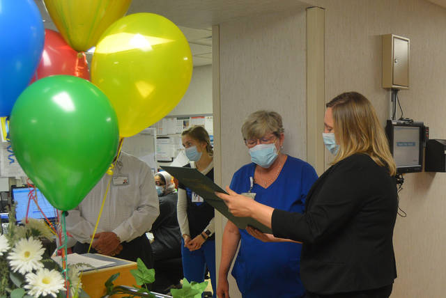 Wayne HealthCare RN and Charge Nurse Deb Osborne looks over The Healing Touch Sculpture she was presented by VP of Patient Care Services and Chief Nursing Officer Kim Freeman as part of the DAISY Award Wednesday.